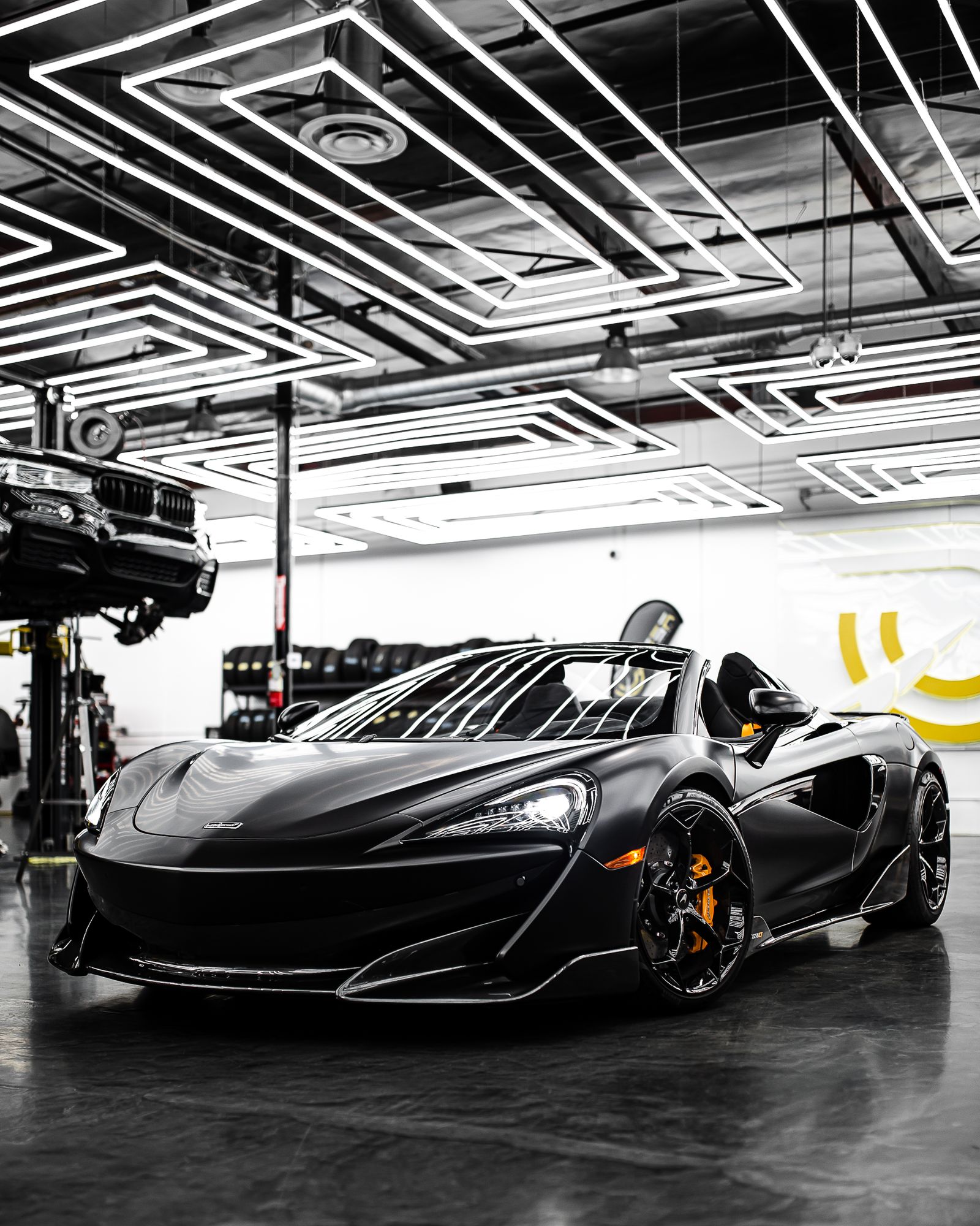 Black performance sports car in an illuminated garage